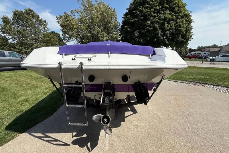 Slide: The Image of 1995 Checkmate Persuader 261 boat with purple accents, parked on a driveway. - 15