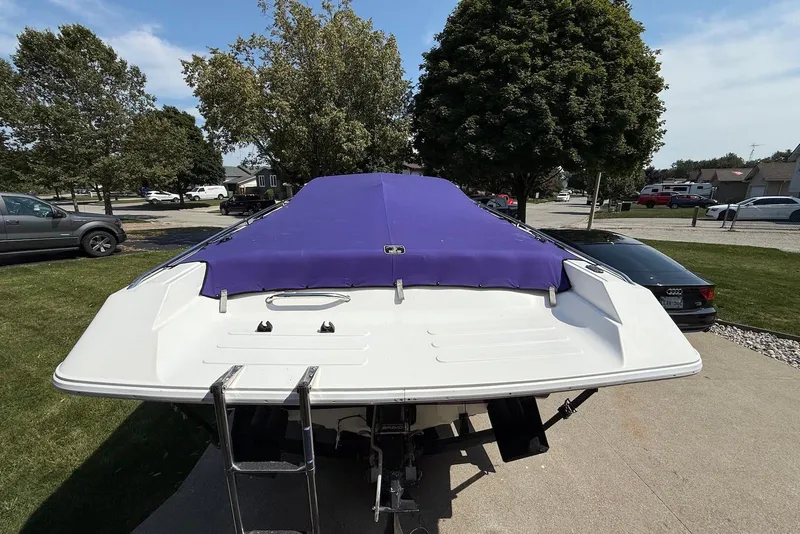 Slide: The Image of 1995 Checkmate Persuader 261 boat with purple cover, parked outdoors. - 16