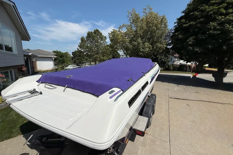 Slide: The Image of 1995 Checkmate Persuader 261 boat with purple cover on trailer in driveway. - 18