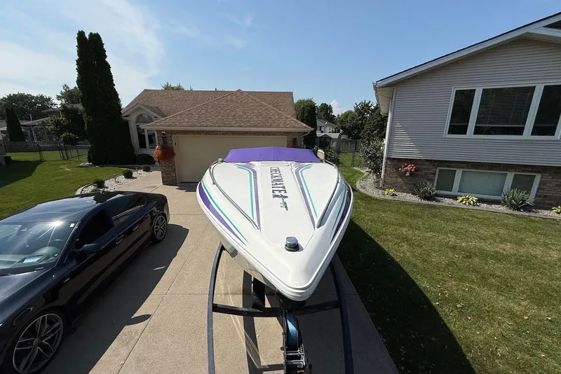Slide: The Image of 1995 Checkmate Persuader 261 boat on trailer in residential driveway, sunny day. - 20