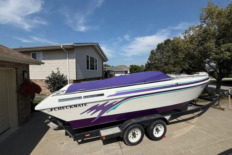 Slide: The Image of 1995 Checkmate Persuader 261 boat on trailer, parked in residential driveway. - 21