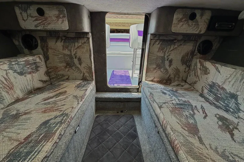 Slide: The Image of Interior of a 1995 Checkmate Persuader 261 boat with patterned seating and storage compartments. - 35