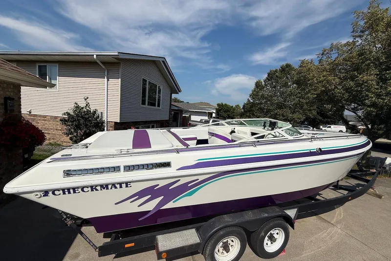Slide: The Image of 1995 Checkmate Persuader 261 boat with purple and teal accents on a trailer. - 43