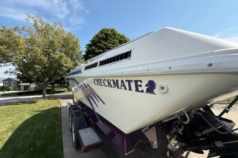 Slide: The Image of 1995 Checkmate Persuader 261 boat on trailer, parked in a suburban neighborhood. - 45