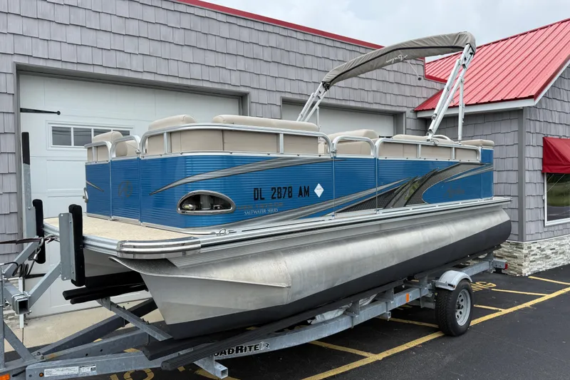 Slide: The Image of 2020 Avalon Venture Cruise 18' pontoon boat on trailer, parked outside a building. - 1