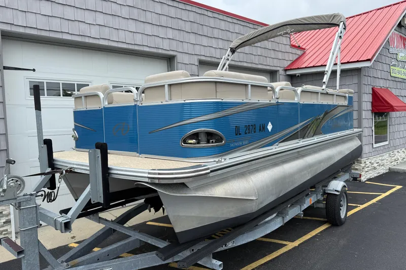 Slide: The Image of 2020 Avalon Venture Cruise 18' pontoon boat on trailer, parked outside a building. - 10