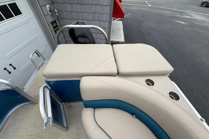 Slide: The Image of 2020 Avalon Venture Cruise 18' boat interior with beige seating and cup holders. - 15