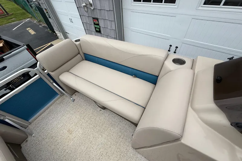 Slide: The Image of 2020 Avalon Venture Cruise 18' boat interior with beige and blue seating. - 16