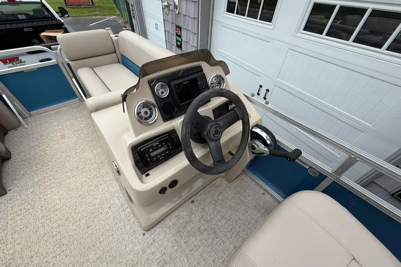 Slide: The Image of 2020 Avalon Venture Cruise 18' boat interior with steering console and seating. - 17