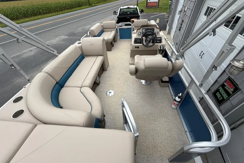 Slide: The Image of 2020 Avalon Venture Cruise 18' pontoon boat interior with beige seating and steering console. - 18