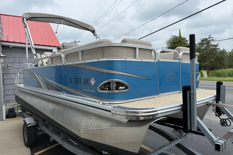 Slide: The Image of 2020 Avalon Venture Cruise 18' pontoon boat on trailer, blue exterior, parked roadside. - 5