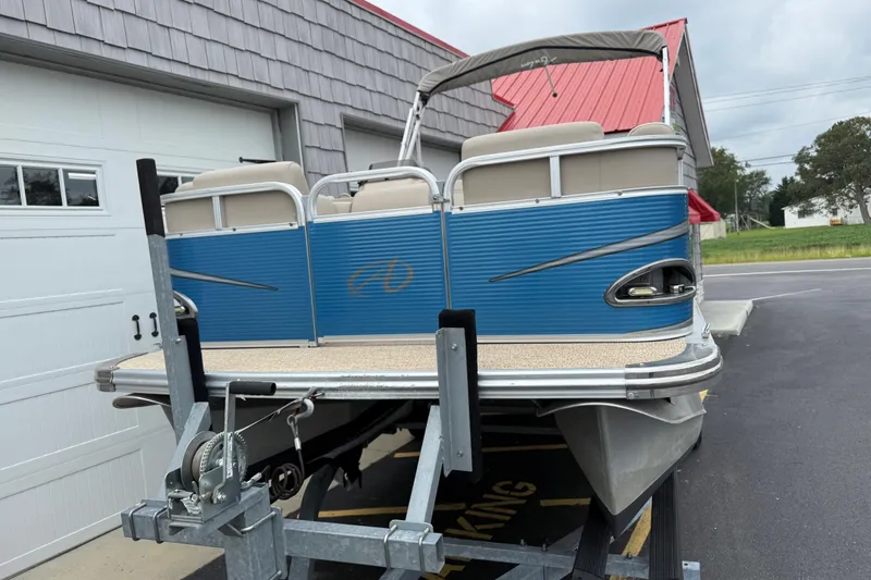 Slide: The Image of 2020 Avalon Venture Cruise 18' pontoon boat on trailer near garage. - 8