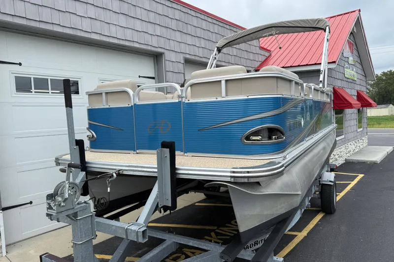 Slide: The Image of 2020 Avalon Venture Cruise 18' pontoon boat on trailer, parked outside a building. - 9
