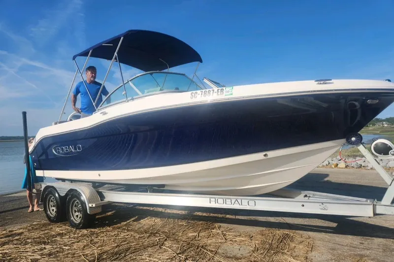 The Image of 2019 Robalo R207 Dual Console boat on trailer, sunny day, waterfront background. - 1