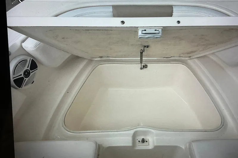 Slide: The Image of 2019 Robalo R207 Dual Console storage compartment with open lid and speaker. - 18