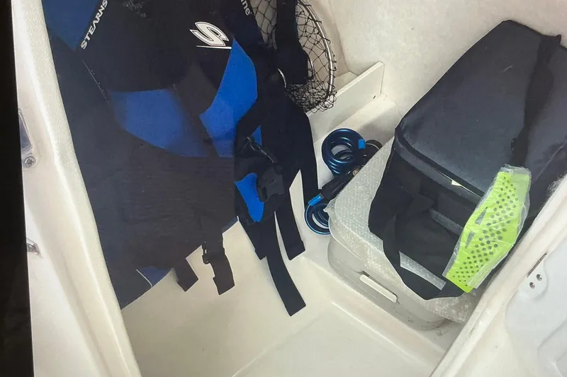 Slide: The Image of Storage compartment in 2019 Robalo R207 Dual Console with gear and accessories. - 22