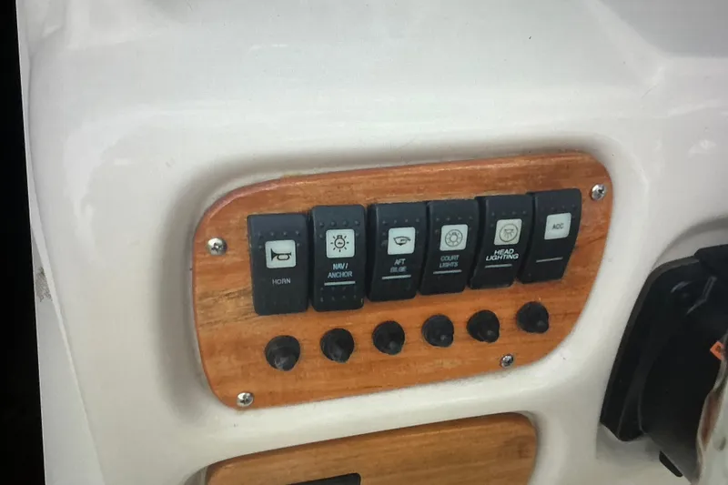 Slide: The Image of Control panel of a 2019 Robalo R207 Dual Console boat with various switches. - 24