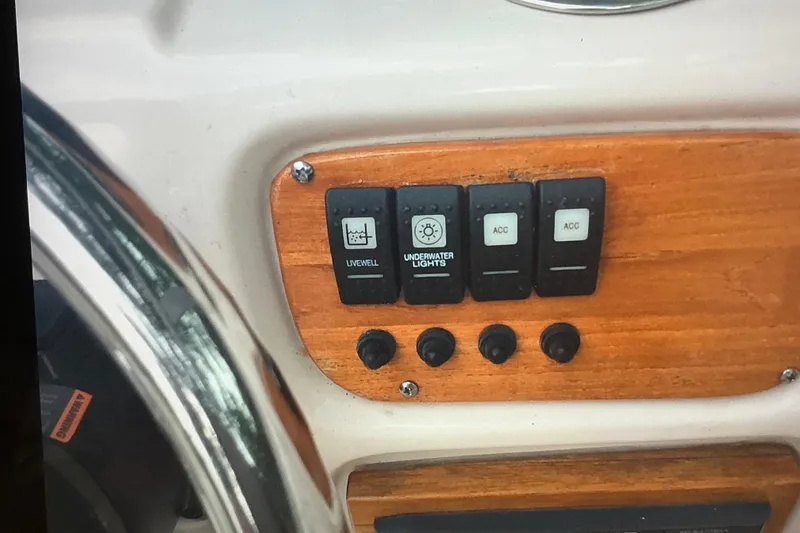 Slide: The Image of Control panel of 2019 Robalo R207 Dual Console with switches for livewell and underwater lights. - 25