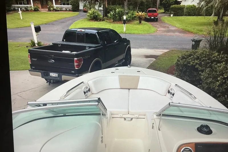 Slide: The Image of 2019 Robalo R207 Dual Console boat on driveway, black truck in background. - 28