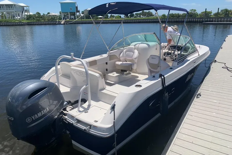 Slide: The Image of 2019 Robalo R207 Dual Console boat docked with Yamaha engine, blue and white design. - 3