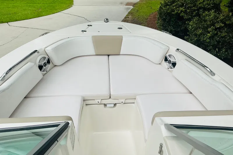 Slide: The Image of 2019 Robalo R207 Dual Console boat with white cushioned seating and speakers. - 9