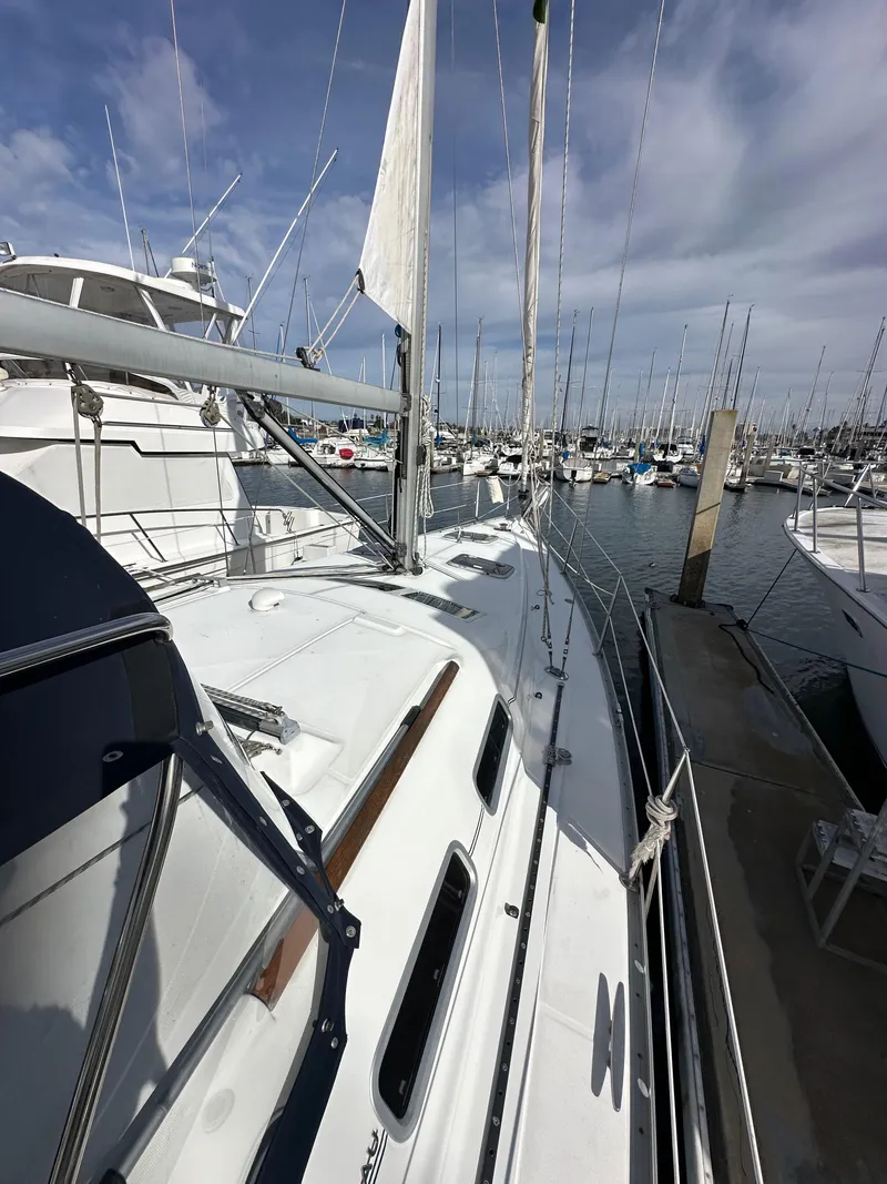 Slide: The Image of 2005 Beneteau 373 sailboat docked at a marina under a partly cloudy sky. - 17