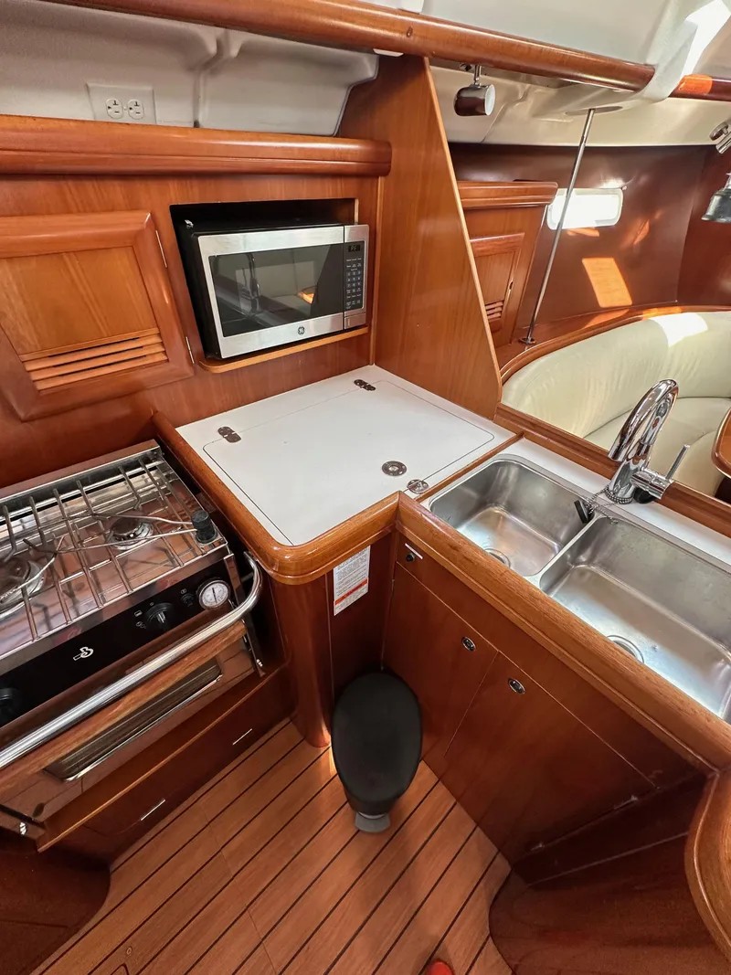 Slide: The Image of 2005 Beneteau 373 yacht kitchen with stove, microwave, and sink. - 33