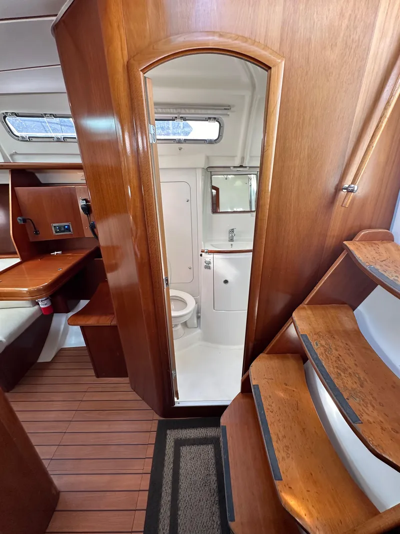 Slide: The Image of Interior of 2005 Beneteau 373 sailboat, featuring wooden cabinetry and compact bathroom. - 36