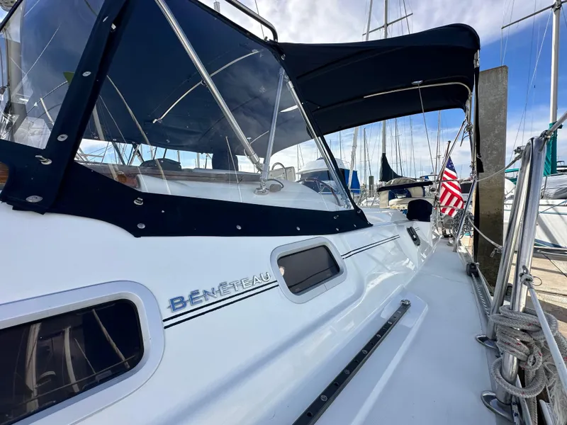 Slide: The Image of 2005 Beneteau 373 sailboat with canopy, docked at marina, American flag visible. - 4