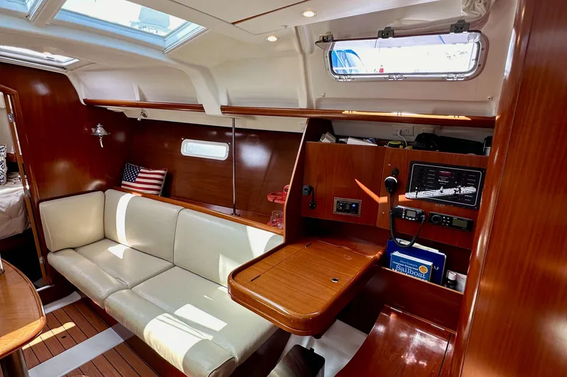 Slide: The Image of Interior of 2005 Beneteau 373 sailboat with wood finish, cream seating, and navigation equipment. - 40