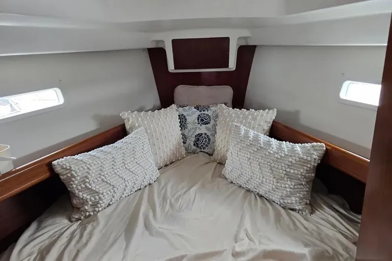 Slide: The Image of Cozy cabin interior of 2005 Beneteau 373 sailboat with plush pillows and wooden accents. - 48