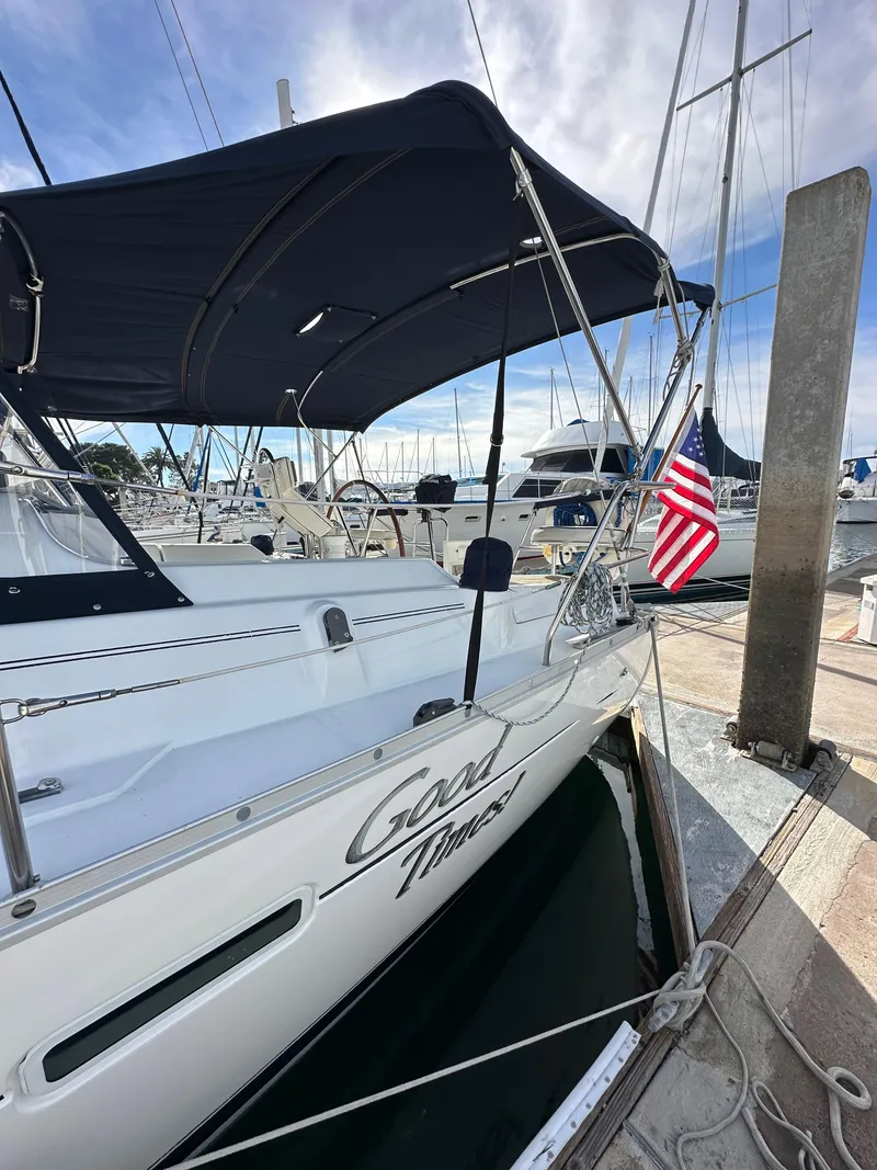 Slide: The Image of 2005 Beneteau 373 sailboat docked, featuring a black canopy and American flag. - 5