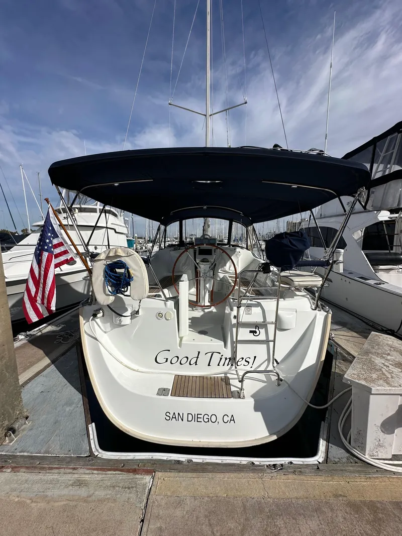 Slide: The Image of 2005 Beneteau 373 sailboat docked in San Diego marina, featuring a navy canopy and American flag. - 6