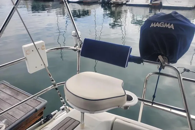 Slide: The Image of Cockpit of 2005 Beneteau 373 sailboat with Magma grill and cushioned seat. - 70