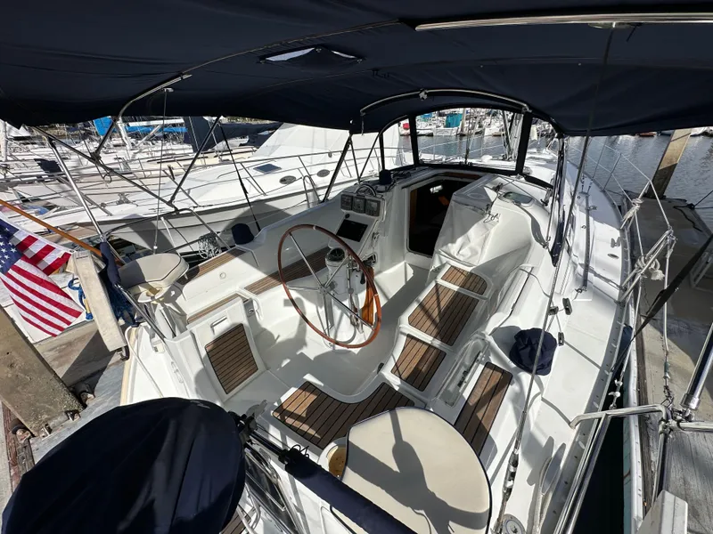 Slide: The Image of 2005 Beneteau 373 sailboat cockpit with wooden accents and steering wheel, docked at marina. - 8