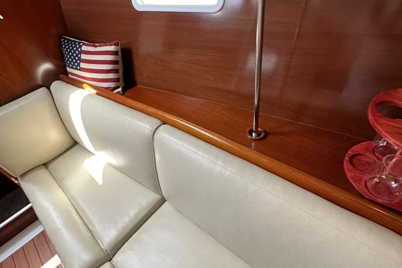Slide: The Image of Interior of 2005 Beneteau 373 yacht with beige seating and American flag pillow. - 83