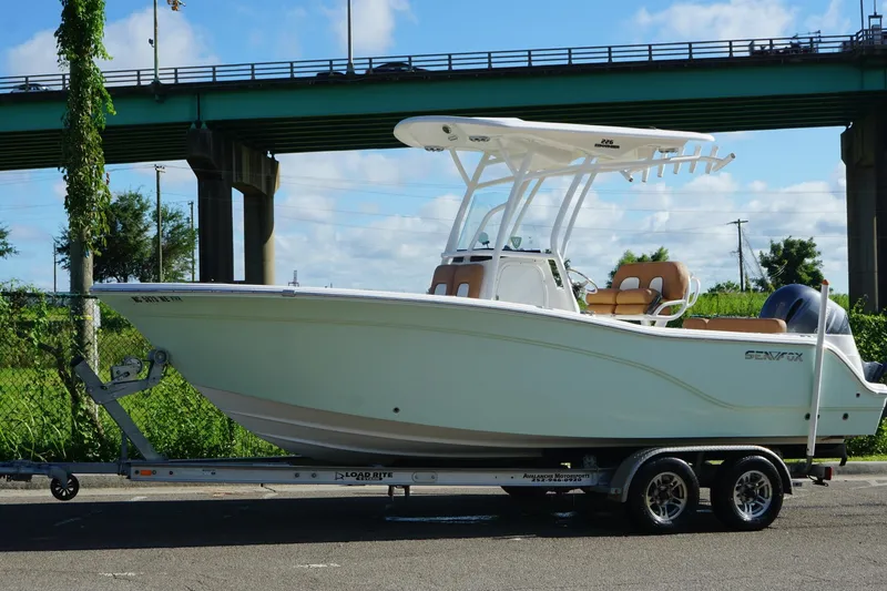 Slide: The Image of 2018 Sea Fox 226 Commander boat on trailer under a bridge, sunny day. - 13