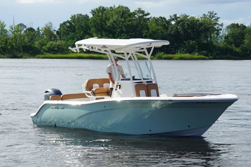 The Image of 2018 Sea Fox 226 Commander boat on calm water with lush green shoreline. - 9