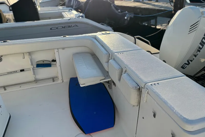 Slide: The Image of 2003 Triton 2690 CC boat interior with seating and storage, docked near other boats. - 10
