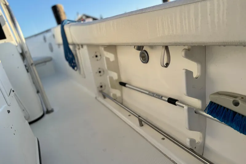 Slide: The Image of 2003 Triton 2690 CC boat interior with storage and cleaning tools. - 12