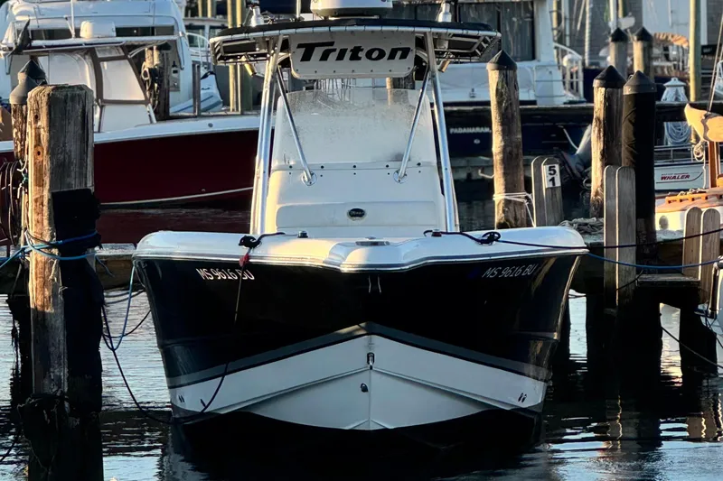 Slide: The Image of 2003 Triton 2690 CC boat docked at a marina, front view. - 3
