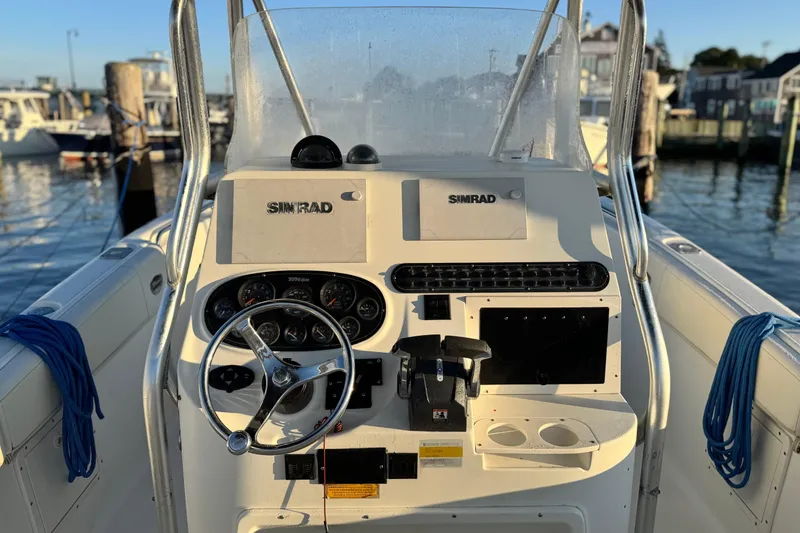 Slide: The Image of 2003 Triton 2690 CC boat dashboard with steering wheel and Simrad navigation system. - 4