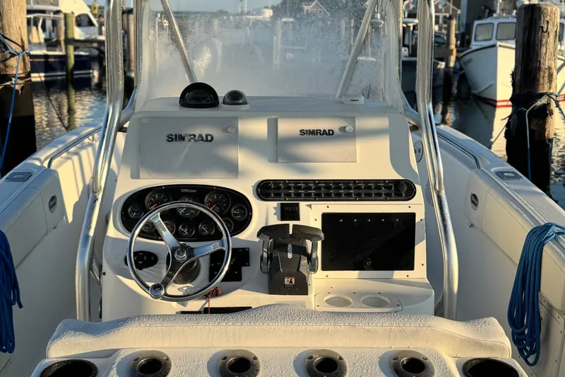 Slide: The Image of 2003 Triton 2690 CC boat dashboard with steering wheel and Simrad navigation system. - 5