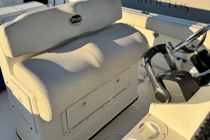 Slide: The Image of 2003 Triton 2690 CC boat interior with steering wheel and cushioned seating. - 7