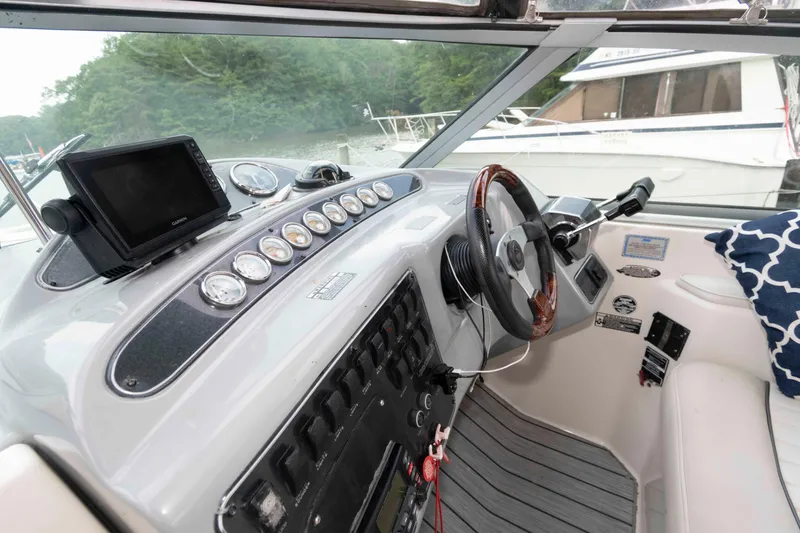 Slide: The Image of 2006 Maxum 3300 SE boat cockpit with steering wheel, gauges, and navigation system. - 2
