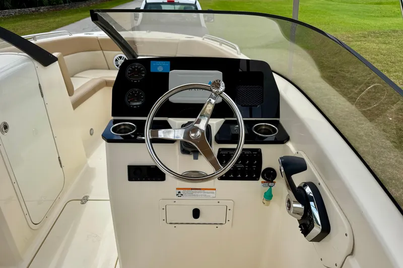 Slide: The Image of 2023 Scout 215 Dorado boat dashboard with steering wheel and controls. - 14