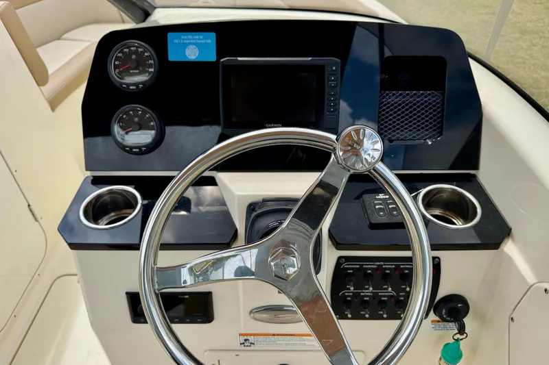 Slide: The Image of 2023 Scout 215 Dorado boat dashboard with steering wheel and gauges. - 15