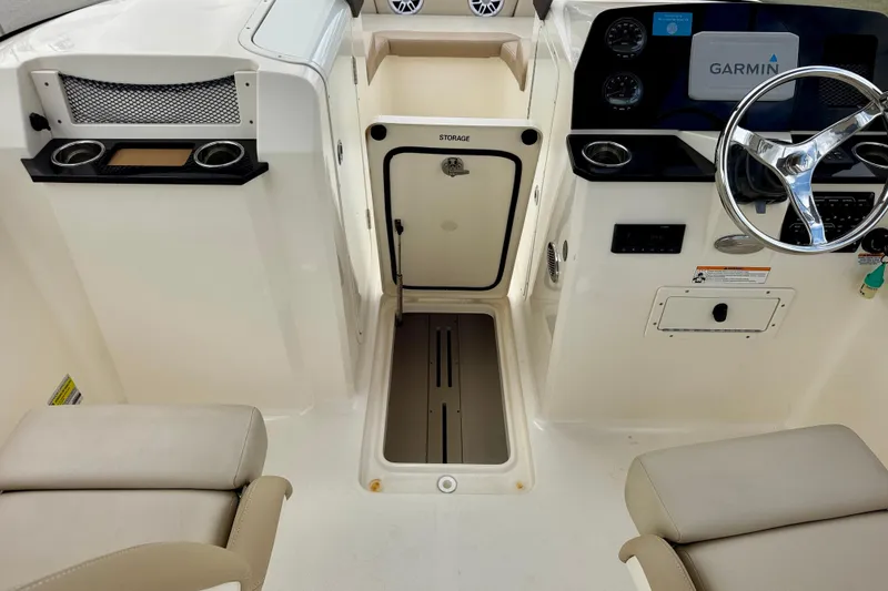Slide: The Image of 2023 Scout 215 Dorado boat interior with storage, steering wheel, and Garmin display. - 26