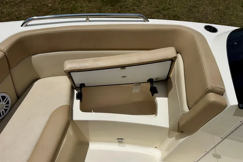Slide: The Image of 2023 Scout 215 Dorado boat interior with open storage compartment and beige seating. - 29