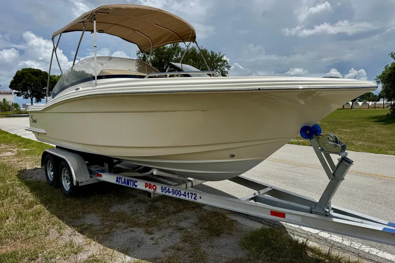 Slide: The Image of 2023 Scout 215 Dorado boat on trailer with canopy, parked outdoors. - 3
